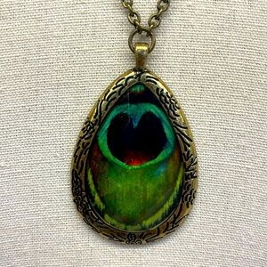 Vintage Peacock Feather Motif Print under a Faceted Clear Bead Pendant Necklace.